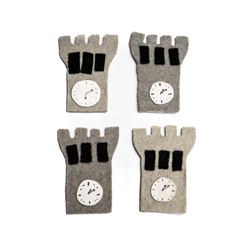 Kvadratna postavitev štirih sivih magnetov iz filca v obliki trdnjave na belem ozadju.