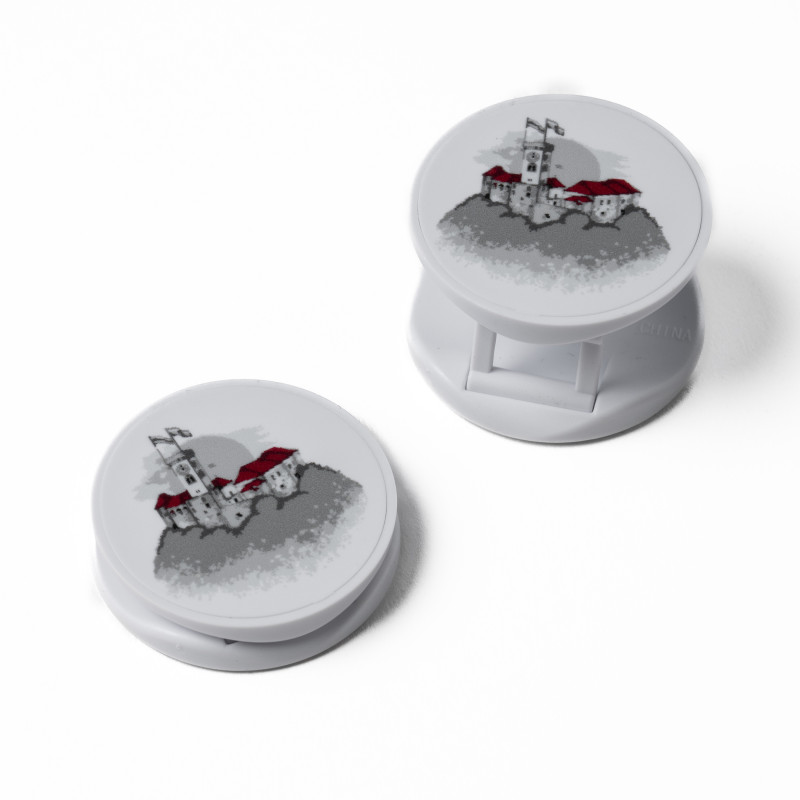 Two white phone holders with the illustrationof Ljubljana Castle, one closed and one opened