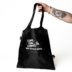 Roka modela drži črno vrečo. Na vreči je bel potisk besedila v angleščini.